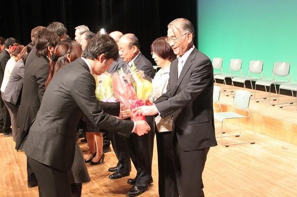 退職者達に花束贈呈をしている写真